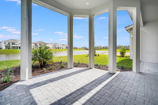 unfurnished sunroom with a residential view and a water view