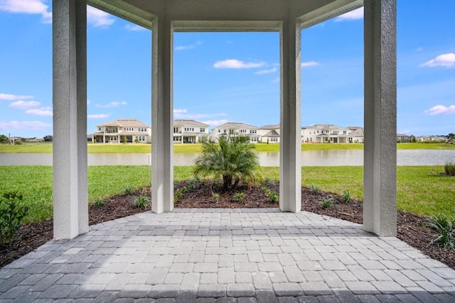 unfurnished sunroom featuring a water view and a residential view