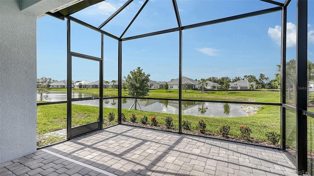 unfurnished sunroom featuring a water view