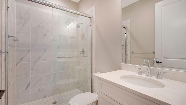 bathroom with vanity, toilet, and a shower with door