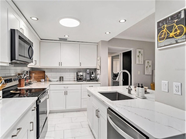 kitchen with stainless steel appliances, ornamental molding, tasteful backsplash, and light tile floors