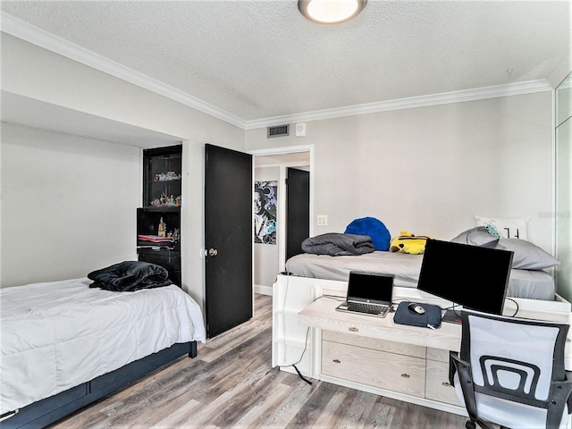 bedroom featuring crown molding, a textured ceiling, and hardwood / wood-style floors