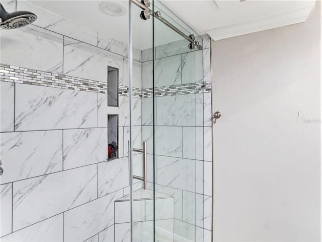 bathroom featuring crown molding and a shower with door