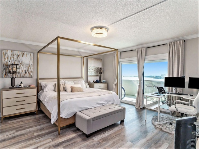 bedroom with a textured ceiling, hardwood / wood-style floors, and access to outside