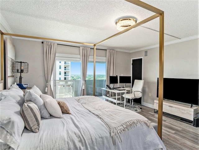 bedroom featuring access to outside, crown molding, hardwood / wood-style flooring, and a textured ceiling