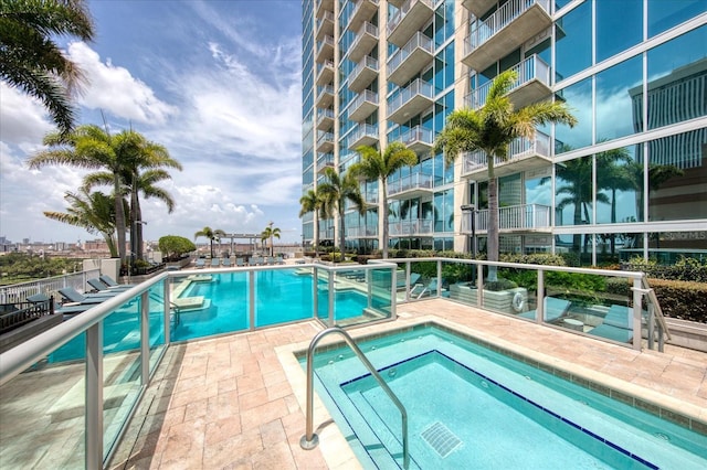 view of swimming pool with a patio and a hot tub