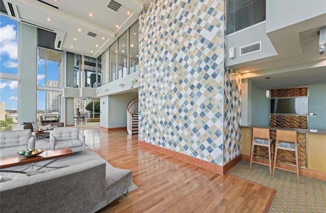 living room featuring a towering ceiling and hardwood / wood-style flooring