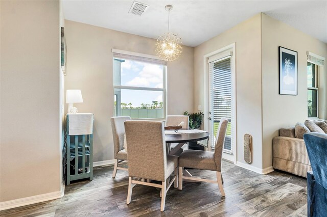 dining area featuring hardwood / wood-style flooring and a notable chandelier