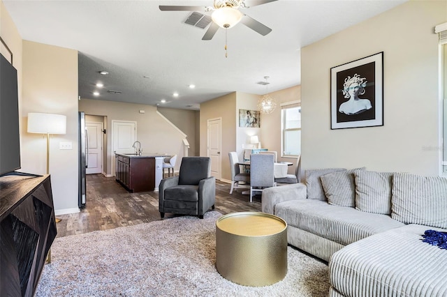 living room featuring ceiling fan, dark hardwood / wood-style flooring, and sink