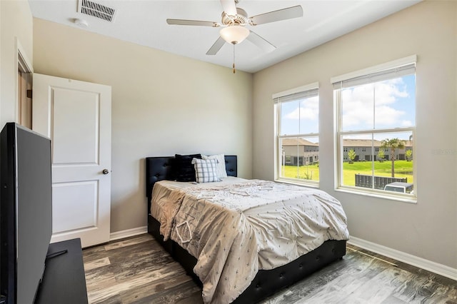 bedroom with ceiling fan and dark hardwood / wood-style floors