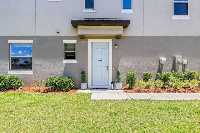 entrance to property featuring a yard