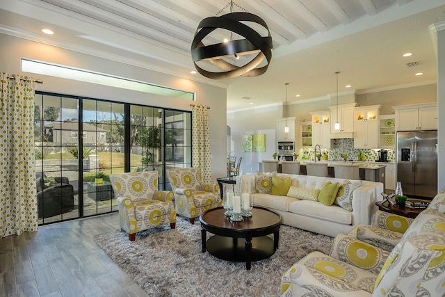 living room with beamed ceiling, ornamental molding, and light hardwood / wood-style flooring