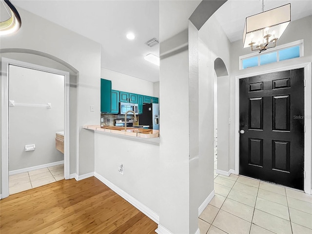 foyer entrance featuring a notable chandelier and light wood-type flooring