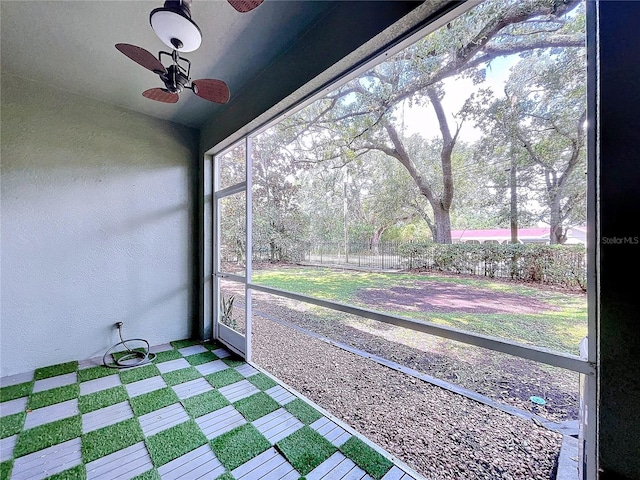 unfurnished sunroom with ceiling fan