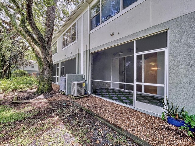 view of property exterior with cooling unit and a sunroom