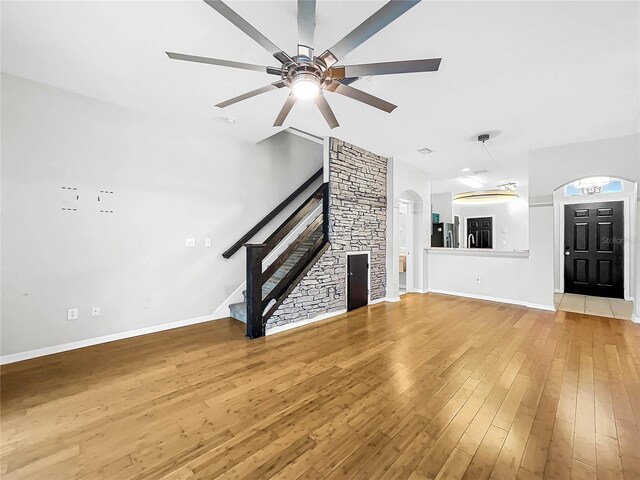 unfurnished living room featuring ceiling fan and hardwood / wood-style flooring