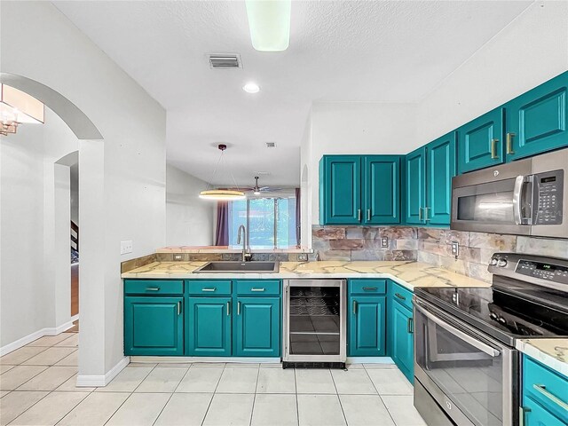 kitchen featuring stainless steel appliances, wine cooler, sink, light tile patterned floors, and ceiling fan