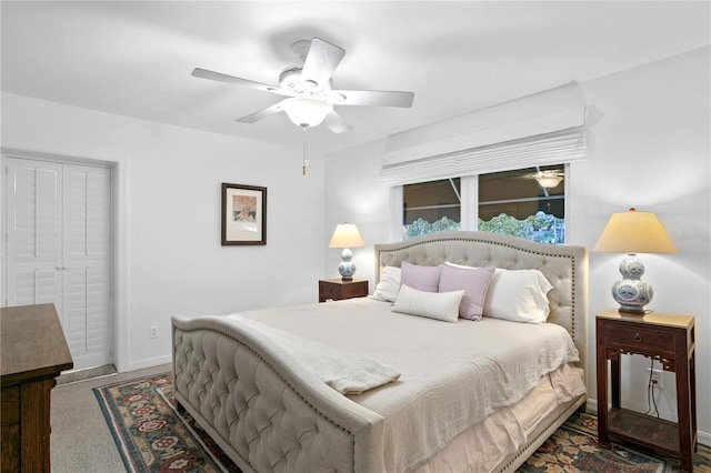 bedroom featuring dark colored carpet, ceiling fan, and a closet