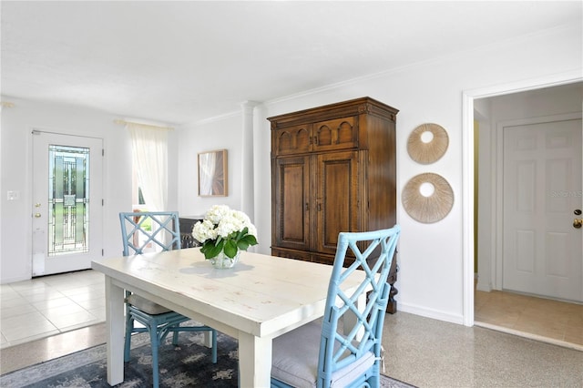 dining area with light tile patterned floors and crown molding