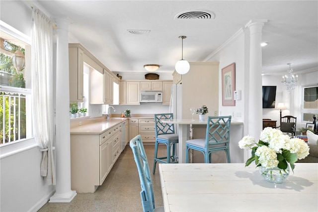 kitchen featuring sink, a breakfast bar area, hanging light fixtures, and a chandelier