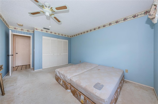 bedroom with light colored carpet, a closet, visible vents, and a textured ceiling