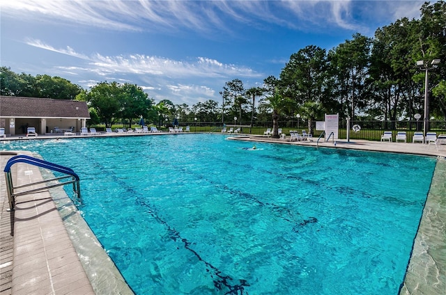 pool with a patio and fence