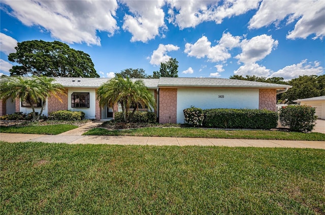 ranch-style house with a front lawn and stucco siding