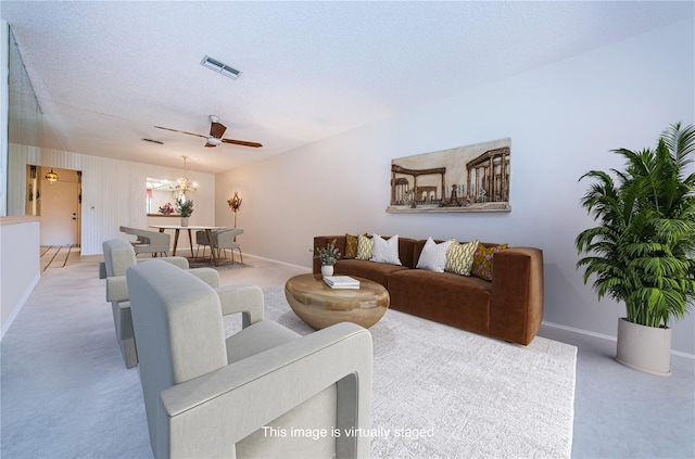 living room featuring light carpet, baseboards, visible vents, and a textured ceiling