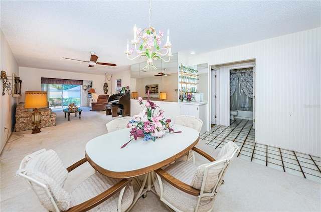 dining space featuring light carpet, light tile patterned flooring, a textured ceiling, and ceiling fan with notable chandelier