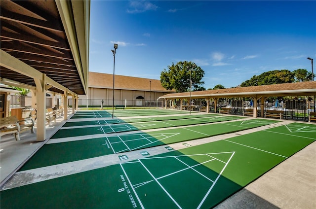 surrounding community featuring fence and shuffleboard