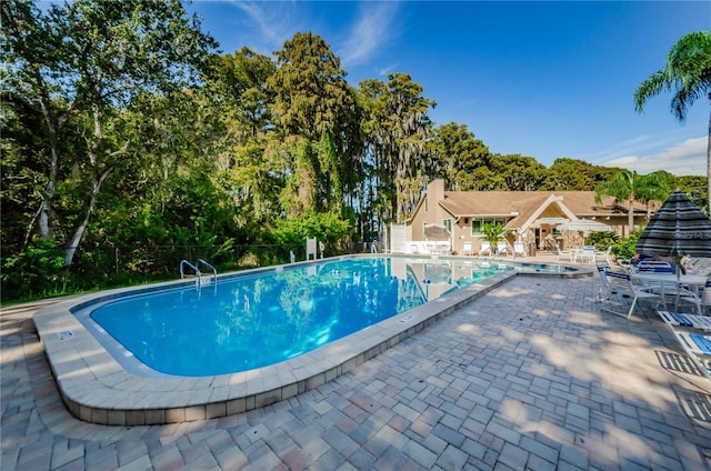 community pool with fence and a patio