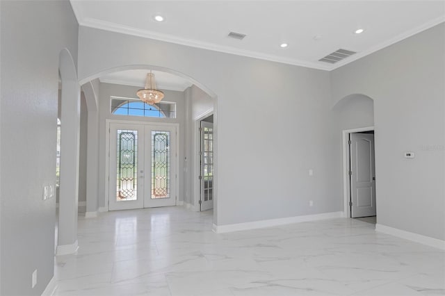 entryway with a chandelier, french doors, and ornamental molding