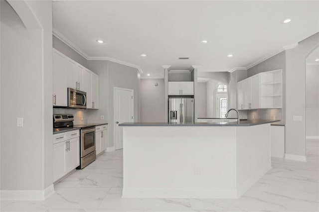 kitchen featuring tasteful backsplash, stainless steel appliances, a kitchen island with sink, sink, and white cabinetry