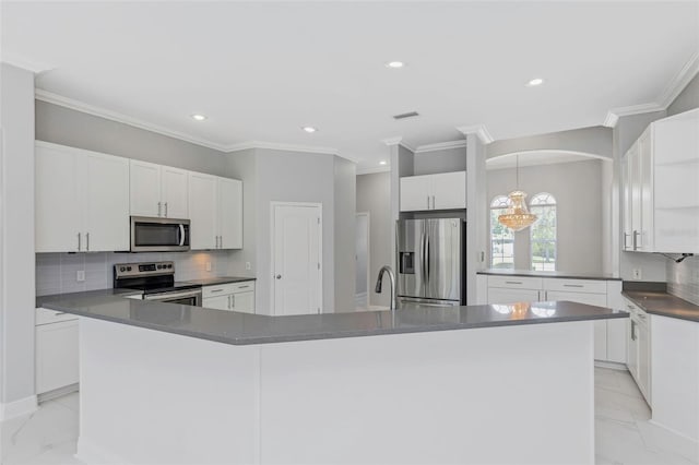 kitchen with a center island, tasteful backsplash, appliances with stainless steel finishes, white cabinets, and ornamental molding