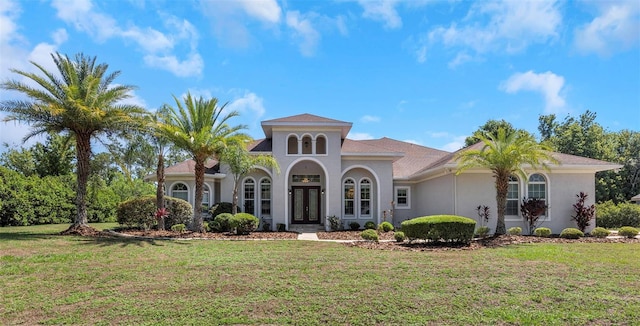 mediterranean / spanish-style house featuring french doors and a front lawn