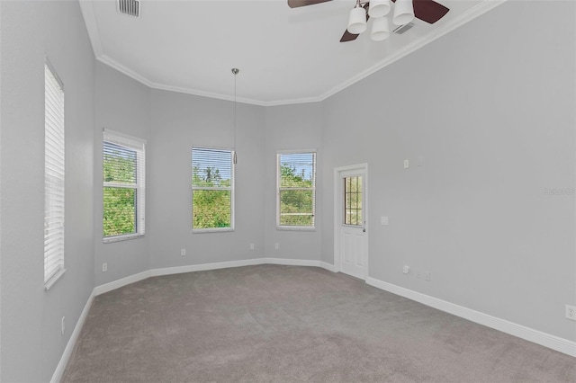 empty room with ceiling fan, light colored carpet, and ornamental molding