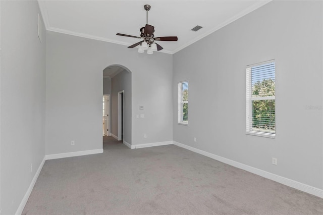 empty room featuring light carpet, ceiling fan, and ornamental molding