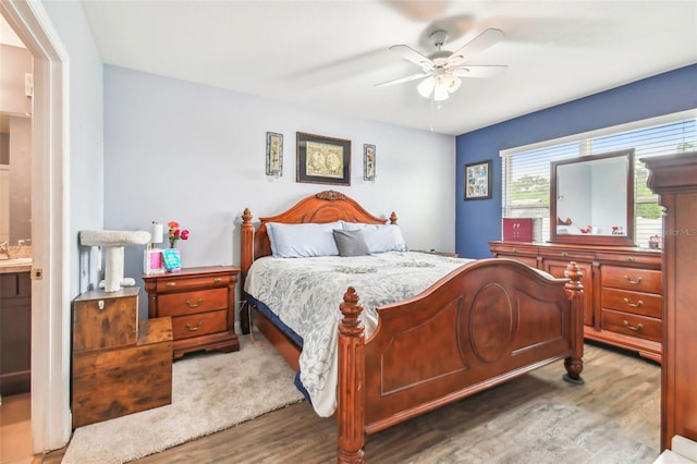 bedroom with ceiling fan, hardwood / wood-style floors, and connected bathroom