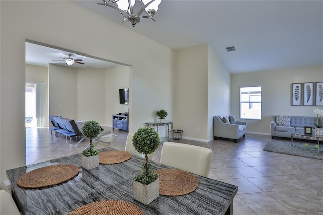 tiled dining area with ceiling fan with notable chandelier