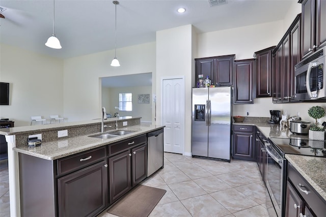 kitchen with stainless steel appliances, dark brown cabinets, pendant lighting, sink, and light tile flooring