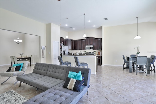 tiled living room featuring high vaulted ceiling and an inviting chandelier