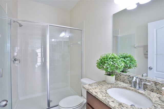 bathroom featuring an enclosed shower, vanity, and toilet