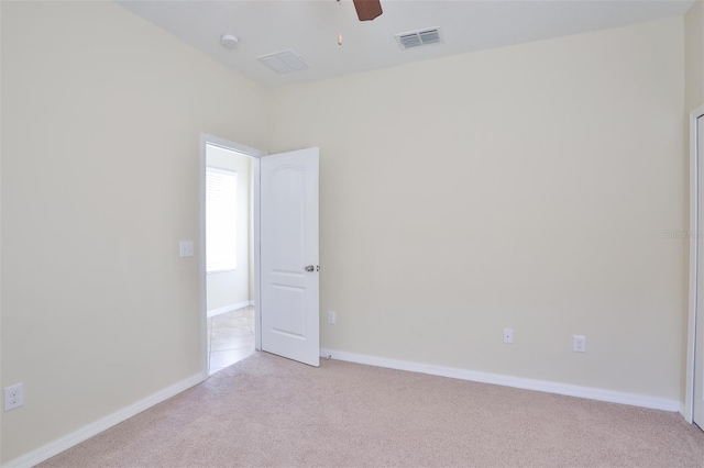 carpeted spare room featuring ceiling fan