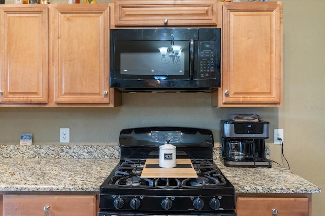 kitchen featuring black appliances and light stone countertops