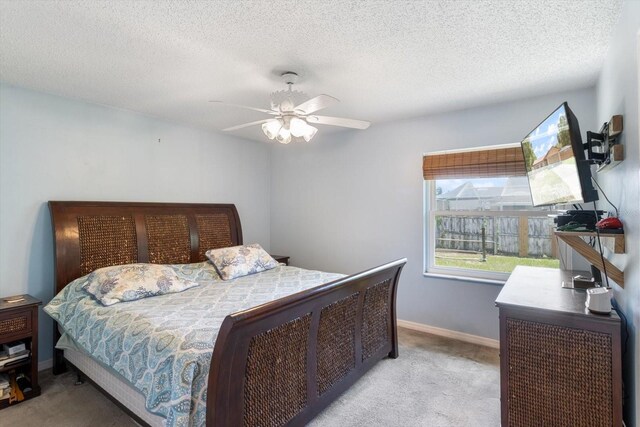 carpeted bedroom with ceiling fan and a textured ceiling