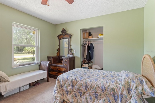 carpeted bedroom featuring multiple windows, a textured ceiling, a closet, and ceiling fan