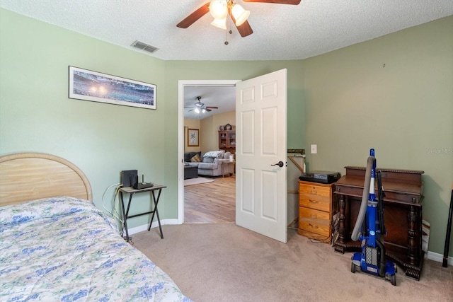 bedroom featuring a textured ceiling, carpet flooring, and ceiling fan