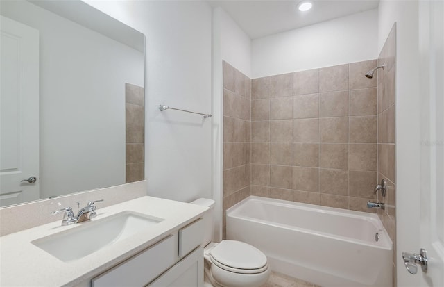 full bathroom featuring tiled shower / bath, toilet, and vanity