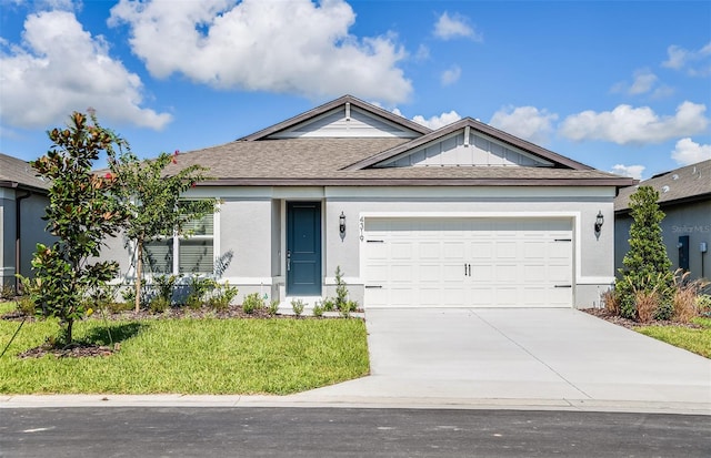 ranch-style home with a shingled roof, concrete driveway, an attached garage, a front lawn, and stucco siding