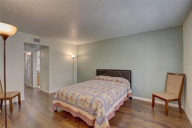 bedroom with dark hardwood / wood-style floors